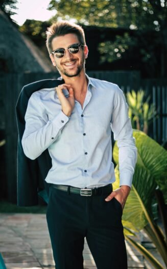 Homme veste sur l'épaule en costume montrant sa chemise en soie bleu clair ©Pexels chloekalaartist