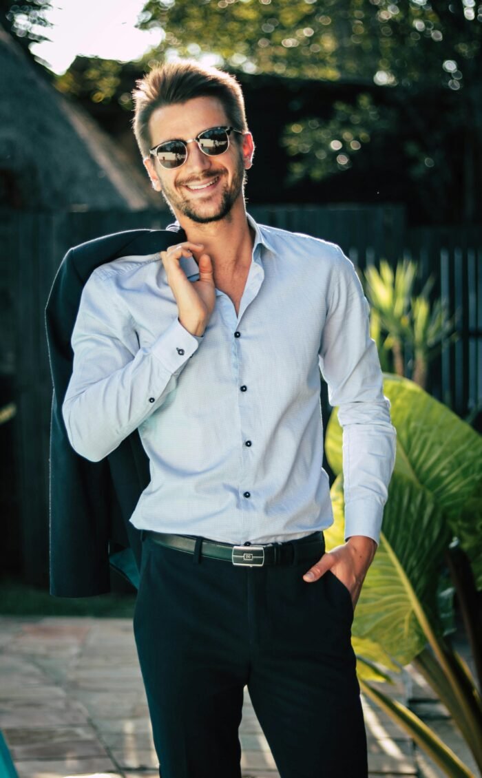 Homme veste sur l'épaule en costume montrant sa chemise en soie bleu clair ©Pexels chloekalaartist